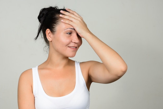 Retrato de mujer hermosa feliz contra la pared blanca