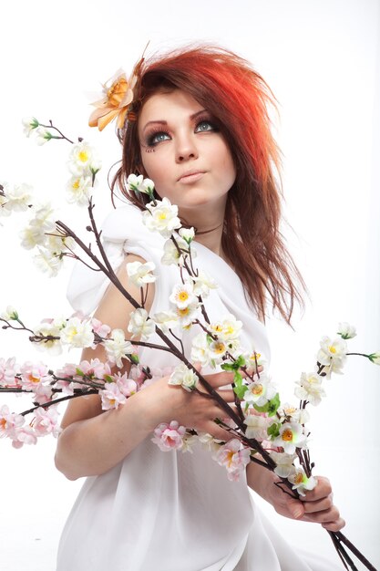 Retrato de mujer hermosa con flores de primavera en blanco