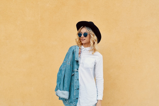 Retrato de mujer hermosa con gafas de sol y un sombrero al aire libre