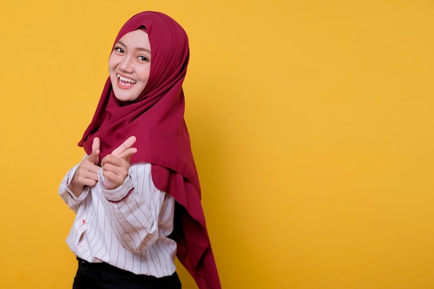 Retrato de mujer hermosa con hijab apuntando hacia ti y sonrisa, expresión alegre