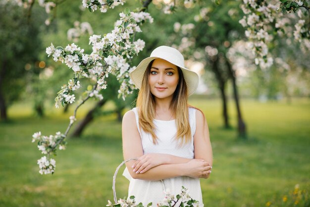 Retrato de una mujer hermosa joven en las flores de primavera de un manzano