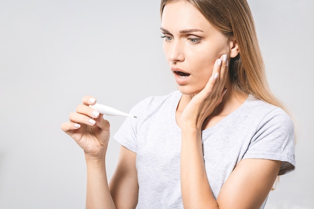 Retrato de una mujer hermosa joven que controla su temperatura