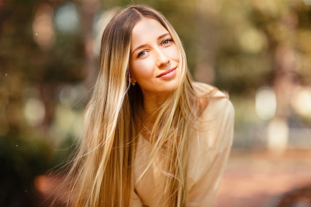 Retrato de mujer hermosa con largo cabello rubio al aire libre