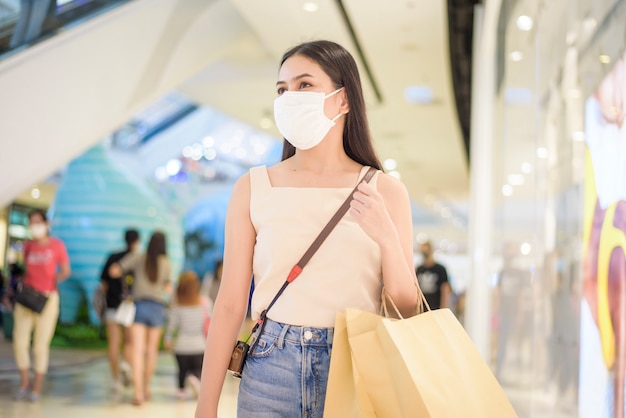 Retrato de mujer hermosa lleva mascarilla en el centro comercial