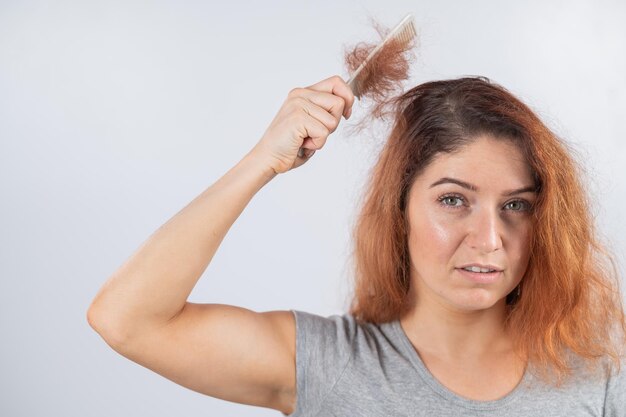 Retrato de una mujer hermosa con la mano contra un fondo blanco