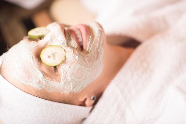 retrato de mujer hermosa con máscara cosmética en la cara en el salón de spa y bienestar