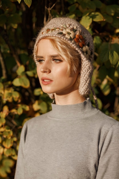 Retrato de mujer hermosa en la naturaleza vistiendo gorro de punto