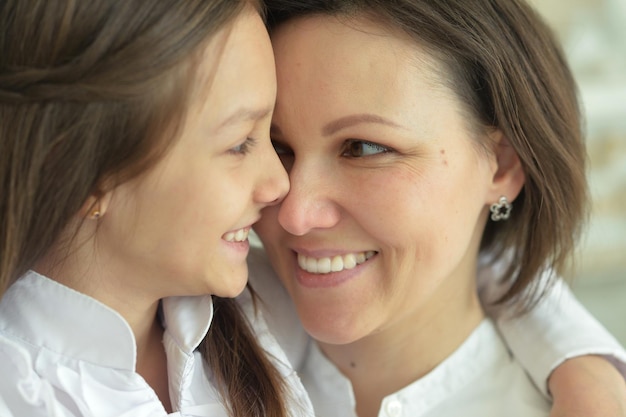 Retrato de mujer hermosa y niña posando en casa