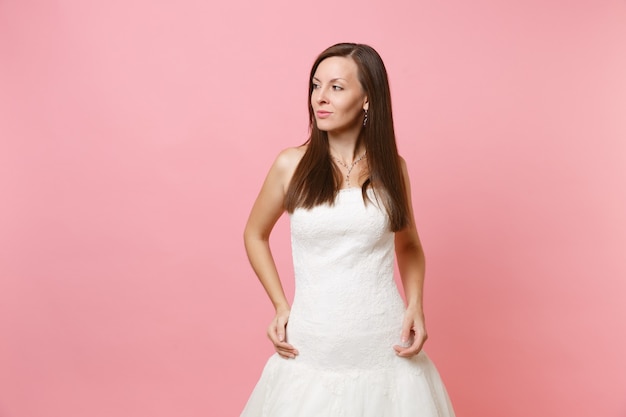 Retrato de mujer hermosa pasión en vestido blanco perfecto de pie y mirando a un lado