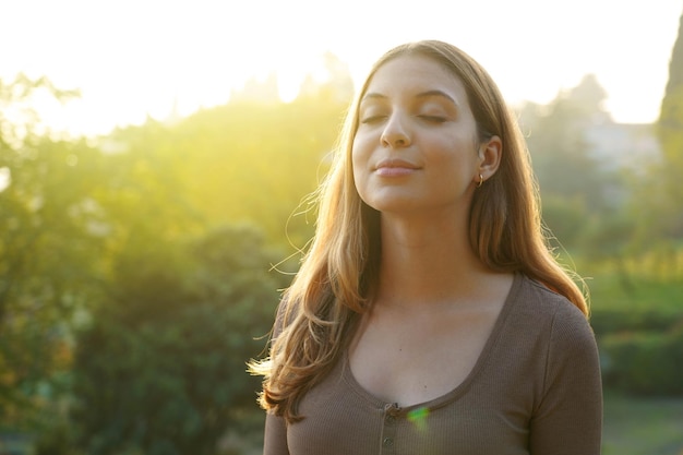 Foto retrato de una mujer hermosa respirando aire fresco contra un fondo natural.