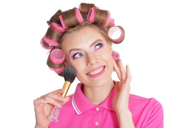 Retrato de mujer hermosa en rizadores de pelo en estudio