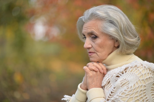 Retrato de mujer hermosa senior triste en el parque