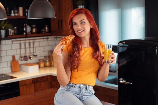 Retrato de una mujer hermosa sosteniendo un vaso con jugo sabroso en el interior