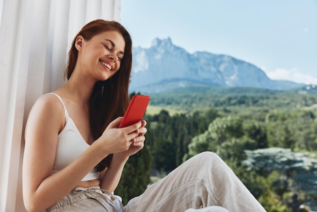 Retrato de mujer hermosa con una terraza de teléfono rojo estilo de vida de ocio de paisaje de lujo al aire libre