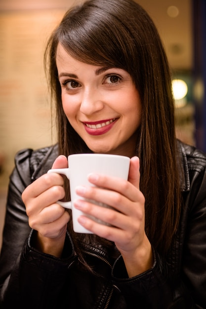 Retrato de mujer hermosa tomando un café