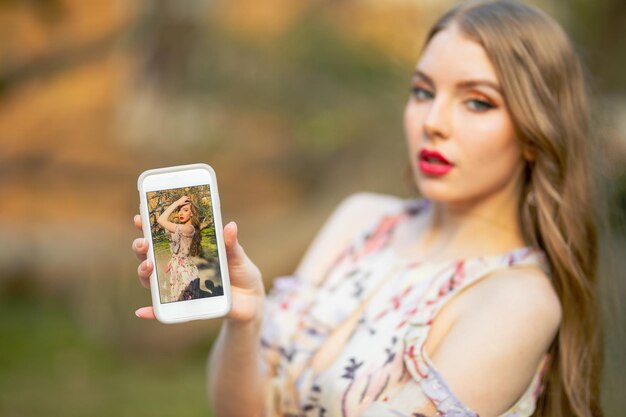 Foto retrato de una mujer hermosa usando un teléfono móvil al aire libre
