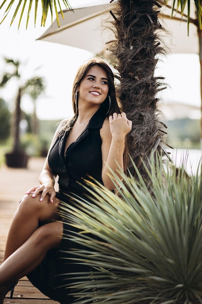 Retrato de mujer hermosa en vestido negro en días de verano