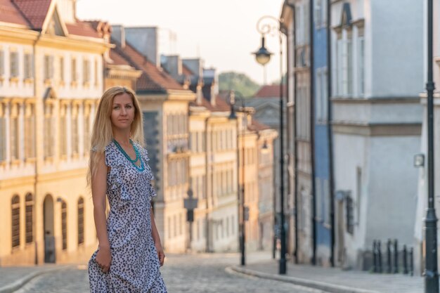 Retrato de una mujer hermosa con un vestido de verano en la calle de la ciudad vieja