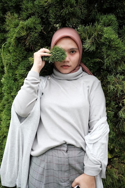 Foto retrato de una mujer con hijab de pie en el campo