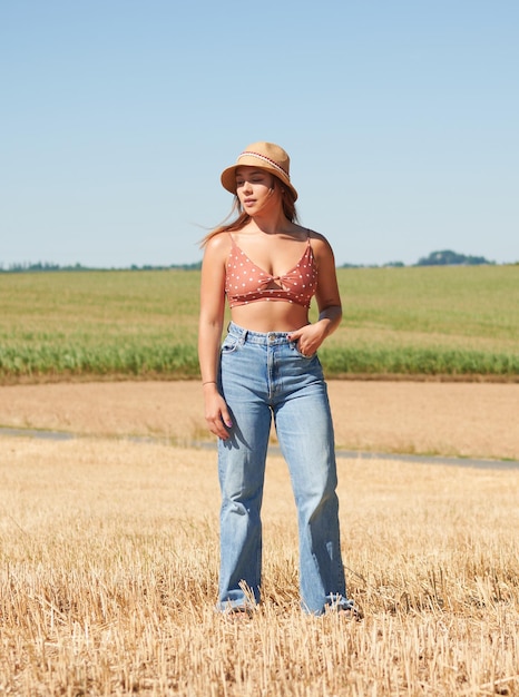 retrato, de, un, mujer hispana, llevando, un, sombrero, posar, en, un, campo de trigo, en, un, soleado, día