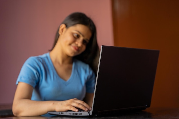 Retrato de una mujer india hermosa y joven que trabaja en su computadora portátil