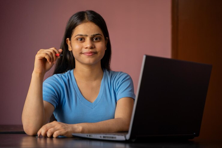 Retrato de una mujer india hermosa y joven que trabaja en su computadora portátil
