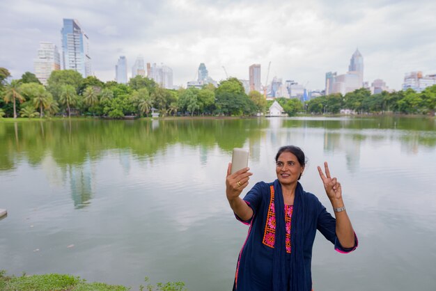 Retrato de mujer india hermosa madura explorando la ciudad de Bangkok, Tailandia