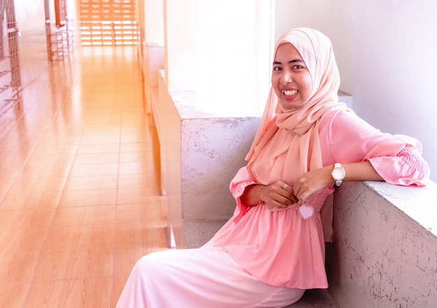 Retrato de mujer islámica joven. Por la mañana ella está sentada y muy feliz.