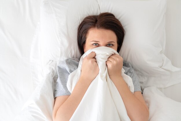 Retrato de una mujer joven acostada en la cama