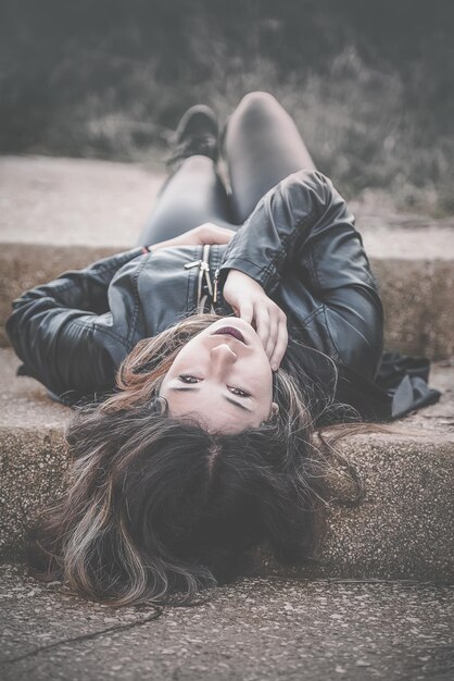 Foto retrato de una mujer joven acostada en los escalones