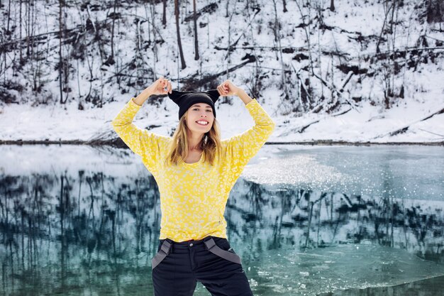 Retrato de mujer joven adulta feliz en el fondo de un hermoso paisaje invernal en la naturaleza