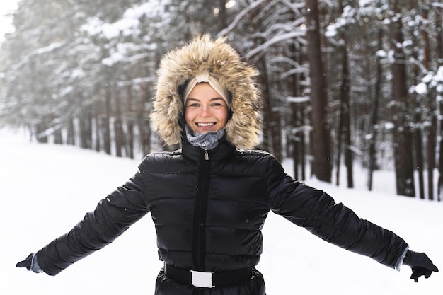 Retrato de mujer joven y alegre disfrutando de caminar durante el hermoso día de invierno