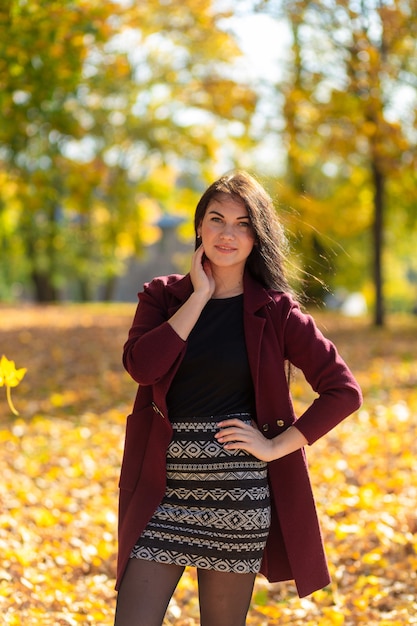 Retrato de una mujer joven alegre disfrutando en el parque de otoño.