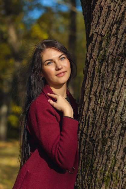 Retrato de una mujer joven alegre disfrutando en el parque de otoño.