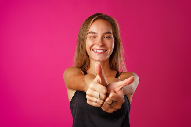 Retrato de una mujer joven alegre mostrando Thumbs up sign close up