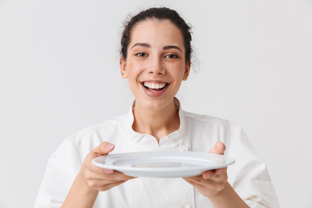 Retrato de una mujer joven alegre con platos