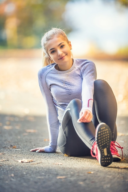 Retrato de una mujer joven antes o después de correr a trotar en el parque de otoño.