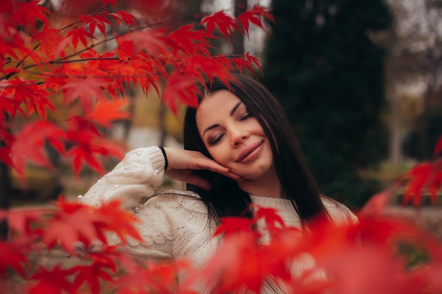 Retrato de una mujer joven y apacible en un parque de otoño.