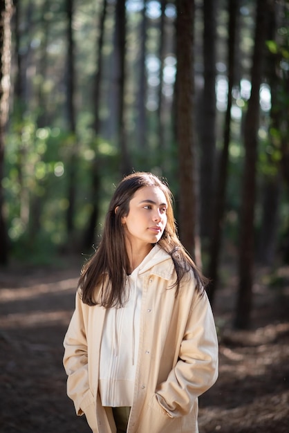 Foto retrato de mujer joven atractiva en el bosque. mujer caucásica con cabello oscuro y ojos verdes mirando hacia los lados. retrato, naturaleza, concepto de belleza.