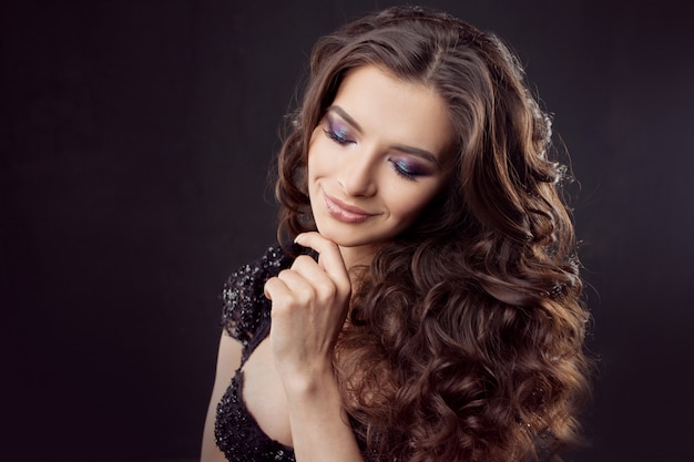 Retrato de una mujer joven y atractiva con un hermoso cabello rizado. Morena atractiva