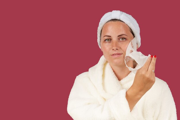 Retrato de una mujer joven atractiva con una mascarilla de tela cosmética