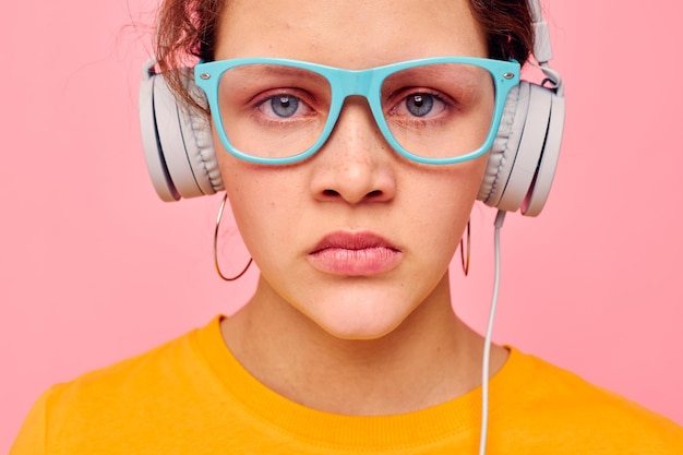 Retrato de una mujer joven con auriculares gafas azules primer plano emociones vista recortada inalterada