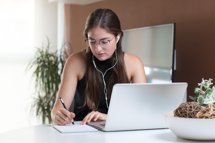 Foto retrato de una mujer joven con auriculares y trabajando