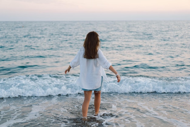 retrato, de, un, mujer joven, bailando, dar la vuelta, por, mar, paisaje marino, en, ocaso, con, hermoso, cielo