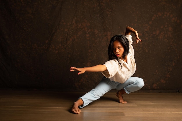 Foto retrato de una mujer joven bailando en el suelo de madera dura