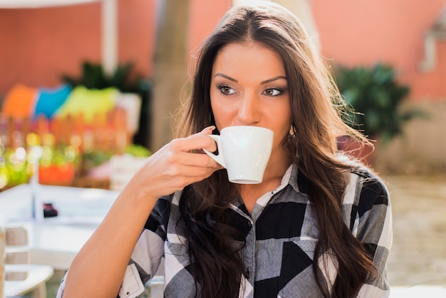 Retrato de mujer joven bebiendo café
