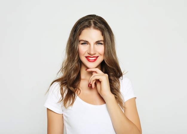 Foto retrato de mujer joven y bonita alegre se siente alegre y riendo aislado sobre fondo blanco.