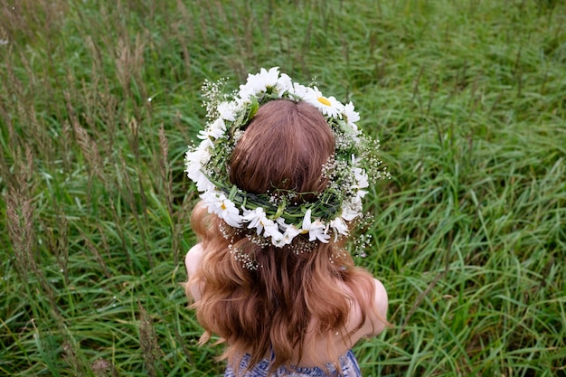 Retrato de mujer joven bonita con diadema de flores de manzanilla en la cabeza