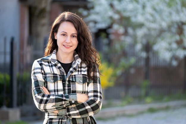 Retrato de mujer joven y bonita sonriendo felizmente relajante al aire libre en un día soleado de primavera.