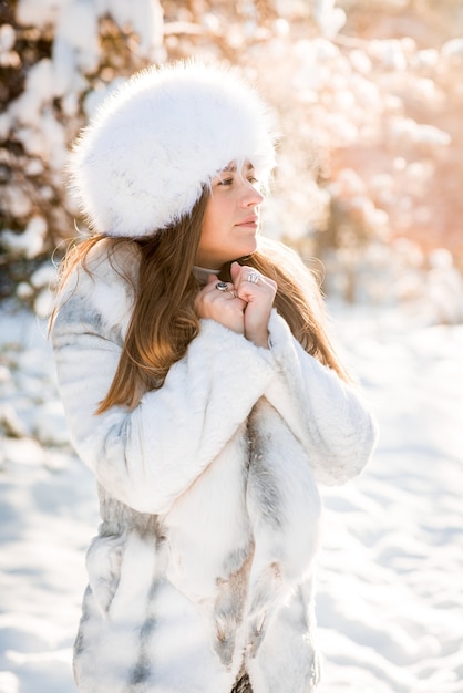 Retrato de mujer joven en el bosque helado de invierno